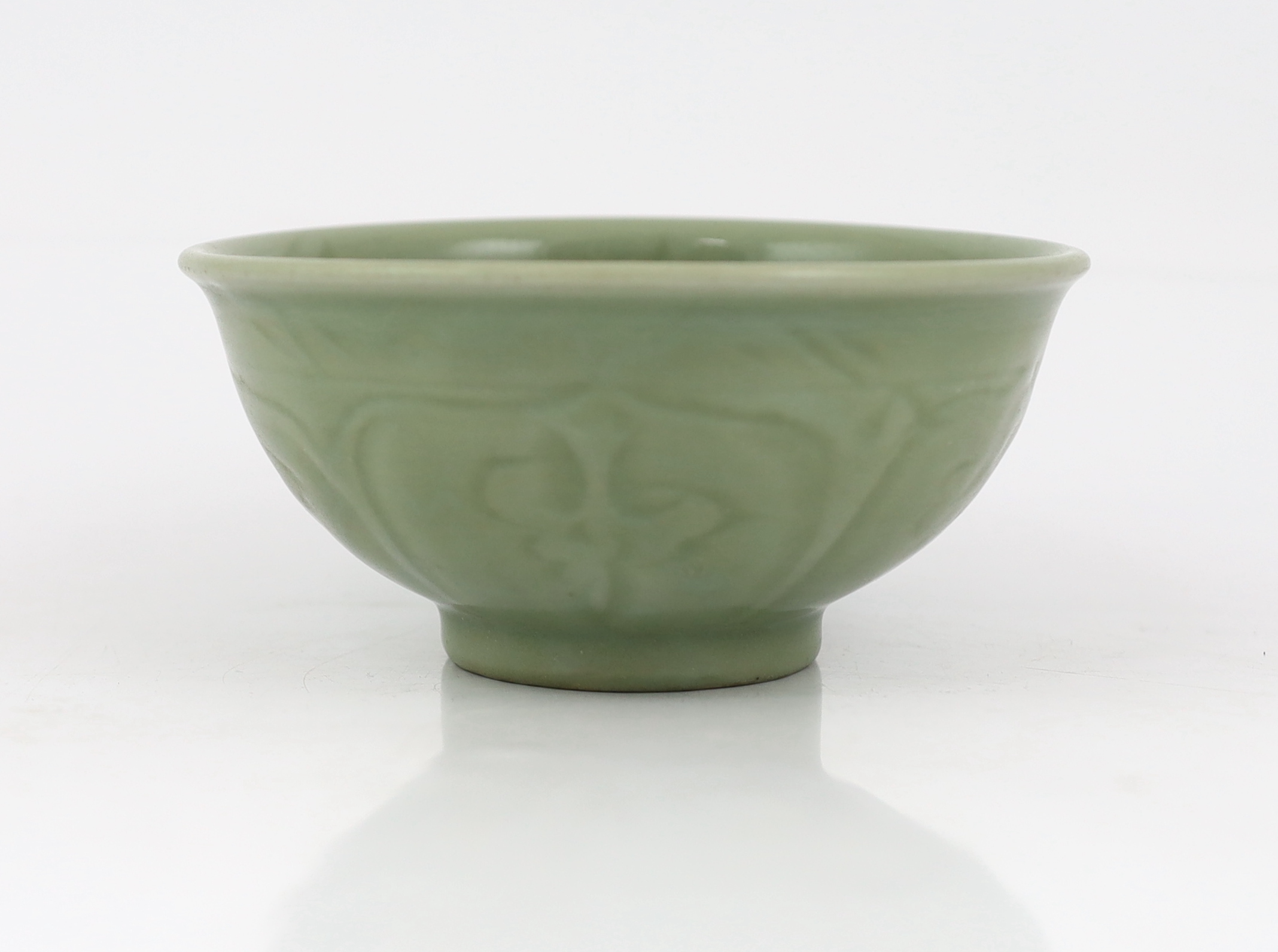 A Chinese Longquan celadon bowl, the interior carved with lotus flowers and the exterior with foliate lappets, 15.2cm diameter., Provenance - Robert Ricketts collection, formerly sold by Robert McPherson, London and S. M